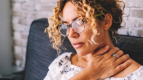 Sick middle age adult young women touching the neck have shoulder and neck pain.Healthcare and medicine concept. Female people suffering shoulder disease at home sitting on the sofa; Shutterstock ID 2264262333