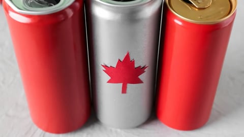 Cans of drink with maple leaf on grey table, closeup. Canadian flag concept; Shutterstock ID 2298106131