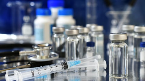 Vaccine booster tripledemic concept background - vials of generic vaccines with syringe and stethoscope; Shutterstock ID 2361205009