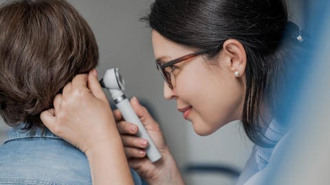 Close up of doctor examining boy's ear with otoscope in medical cabinet. Barotrauma laryngitis otitis ear treatment. Otorhinolaryngology concept; Shutterstock ID 2385189511