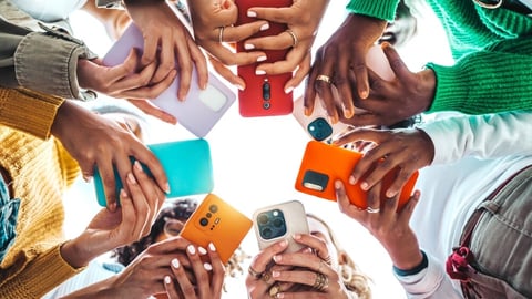 Group of young people using smart mobile phone device outside - Trendy technology concept with guys and girls playing video games app on smartphone - Bright colorful filter; Shutterstock ID 2388175837