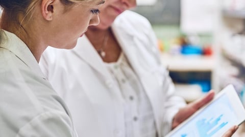 Pharmacist, women and together on tablet for charts, stock or sales stats with reading for analytics. People, mentor and intern on digital touchscreen, application or inspection with graphs at store; Shutterstock ID 2463695177