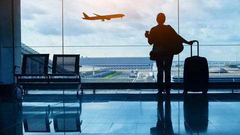 travel by plane, woman passenger waiting in airport, silhouette of passenger watching aircraft taking off; Shutterstock ID 2467550689
