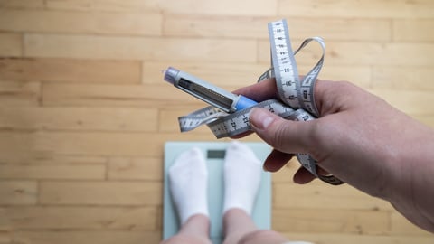 Ozempic Insulin injection pen for diabetics and weight loss. Woman weighs herself and holds Ozempic in her hand. Weight loss concept.; Shutterstock ID 2470013631