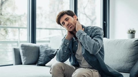 Upset tired young man feeling pain massaging stiff neck rubbing tensed muscles to relieve back ache joint shoulder discomfort after long sedentary work in incorrect posture, fibromyalgia concept; Shutterstock ID 2473263351