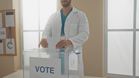 Young hispanic man voting indoors in an electoral college room, casting a ballot.; Shutterstock ID 2520044805
