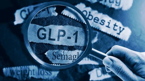 GLP-1 related drugs newspaper headlines with hand and magnifying glass; Shutterstock ID 2552681083