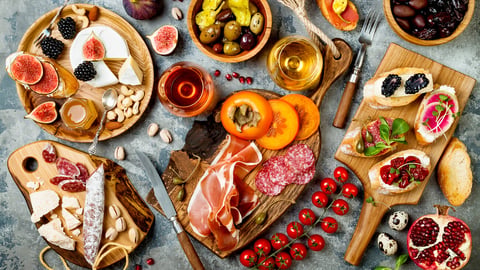 Appetizers table with italian antipasti snacks and wine in glasses. Brushetta or authentic traditional spanish tapas set, cheese variety board over grey concrete background. Top view, flat lay; Shutterstock ID 754215313