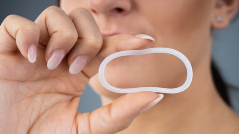 Woman holding vaginal ring