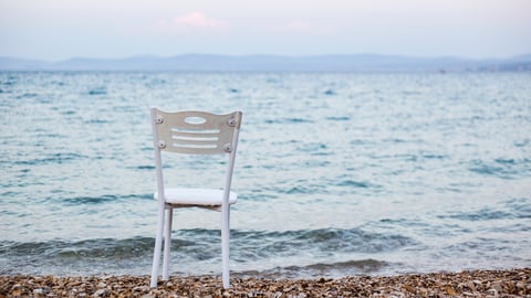 a white chair on a beach