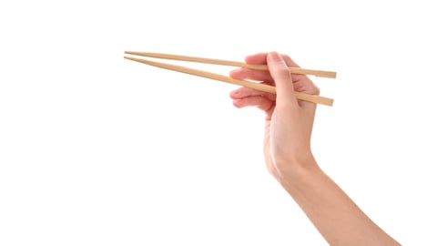 Woman's hand holding up chopsticks