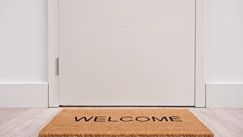 A welcome mat in front of a white door