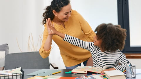 Young woman working with child on art project