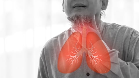 red lungs superimposed over black and white image of man coughing