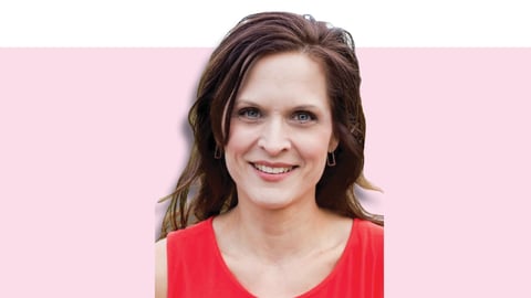 White woman with long brown hair and a bright red top