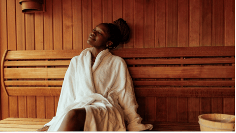 Black woman in robe in sauna