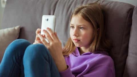 Teen girl on smart phone scrolling social media