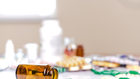 Pill bottle and pills on counter