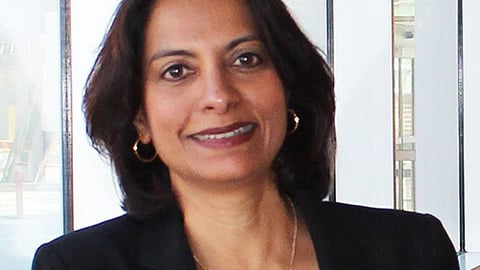 A headshot of a brown woman in a suit