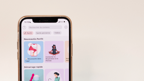 A small purple device sits next to an iPhone with an app open on it