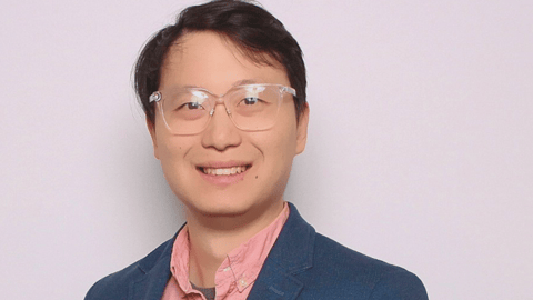 A headshot of Kenny Chan, co-founder of Aiskyra, in a suit in front of a plain background