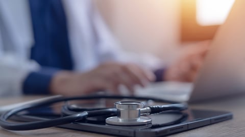 A doctor sits in front of a computer