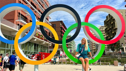 Dr. Mélissa Généreux sits inside a green ring in a sculpture of the Olympic Rings in Paris in 2024