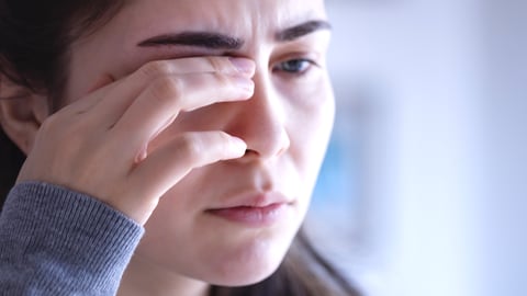 Woman touching her eye