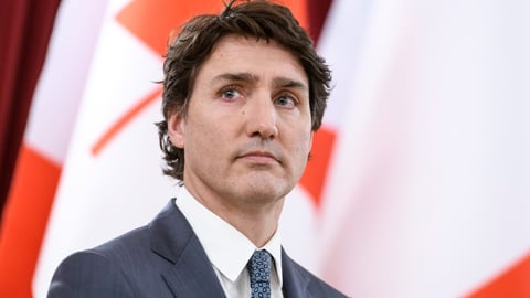 Prime Minister Justin Trudeau in front of a Canadian flag