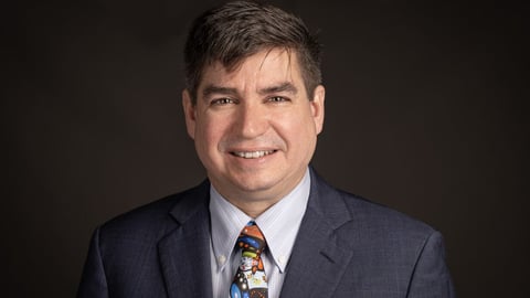 Dr. Michael Green in a suit and tie posing for a professional photo