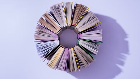 top view of stack of books in circle on violet tabletop; Shutterstock ID 1097077451