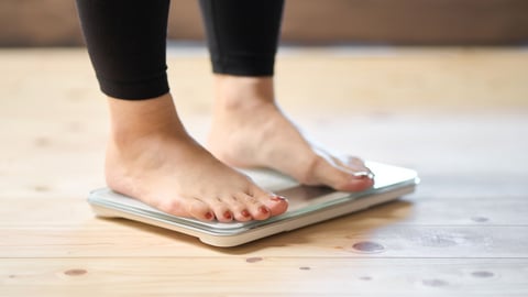 Feet of an Asian woman on a weight scale; Shutterstock ID 2226956351