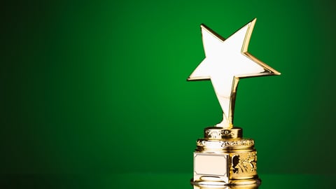 gold star trophy against green background; Shutterstock ID 275008853