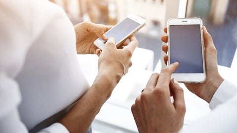 Closely image of woman`s hand is holding cell telephone with copy space screen for your advertising text message, while her friend near dials the number on smart phone. Two female are using cellphones; Shutterstock ID 393506575