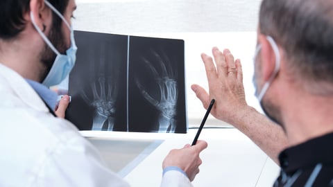 Young doctor examining x-ray of hands of a senior patient with arthritis. Radiography of a hand.; Shutterstock ID 1966496053