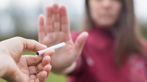 girl refuses a cigarette. woman quits smoking. bad habit.  World No Tobacco Day. human arm is gesturing with refusal. antismoking concept; Shutterstock ID 1737596084