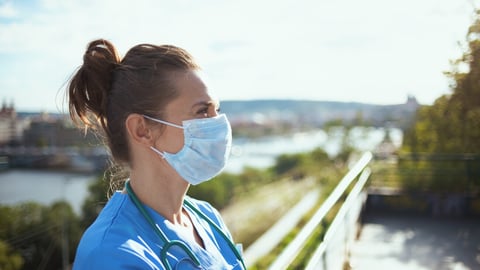 coronavirus pandemic. pensive modern medical doctor woman in scrubs with stethoscope and medical mask looking into the distance outdoors in the city.; Shutterstock ID 1807029211