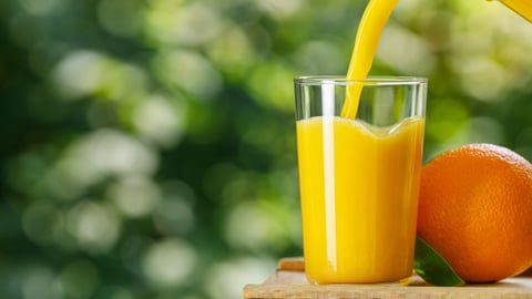 orange juice pouring into glass from jug with ripe fruit on wooden table outdoors; Shutterstock ID 2006307878