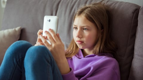 Upset depressed caucasian little kid girl holds mobile phone expresses sorrow and regret blames; Shutterstock ID 2152037861