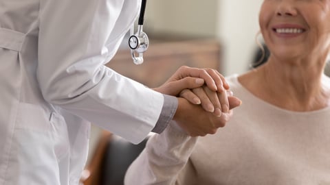 Doctor giving hope. Close up shot of young female physician leaning forward to smiling elderly lady patient holding her hand in palms. Woman caretaker in white coat supporting encouraging old person; Shutterstock ID 1971115256