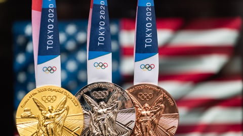 April 25, 2021 Tokyo, Japan. Gold, silver and bronze medals of the XXXII Summer Olympic Games 2020 in Tokyo on the background of the US flag.; Shutterstock ID 1997097425