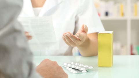 Close up of a pharmacist reading leaflet of a medicine to a patient in a pharmacy indoor; Shutterstock ID 744371557