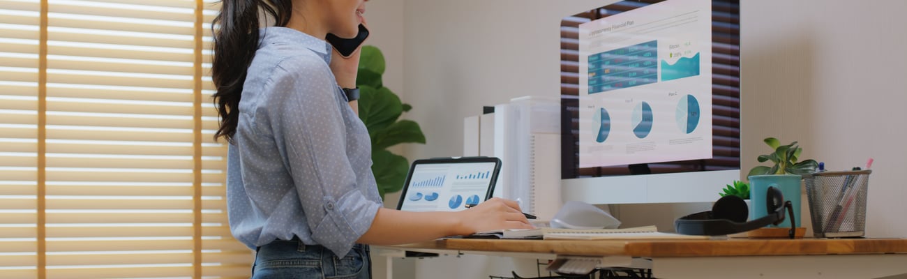 A woman uses a standing desk while working.