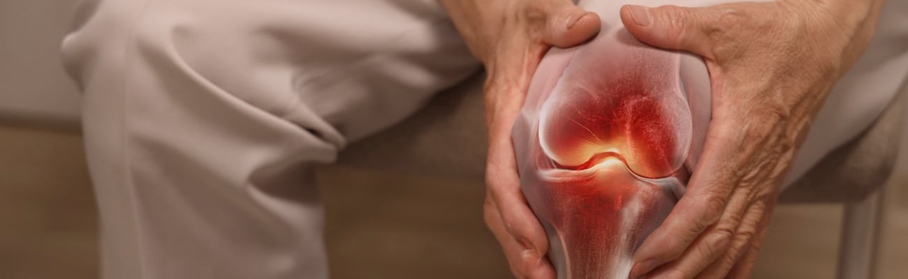 Close up of elderly person holding their knee in pain