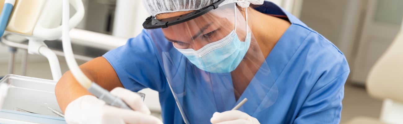 Dentist professional filling teeth for man patient sitting in medical chair