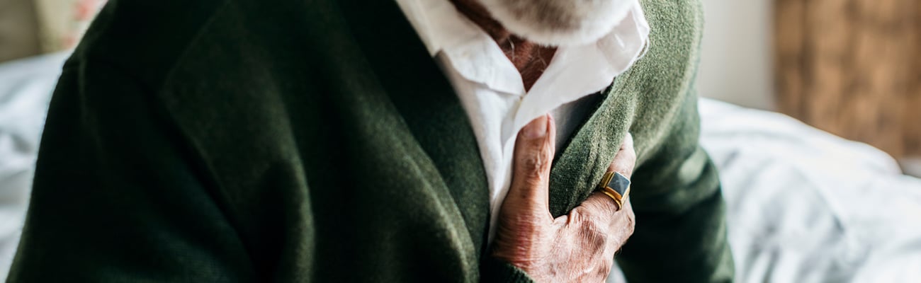 Older man holding his heart in pain