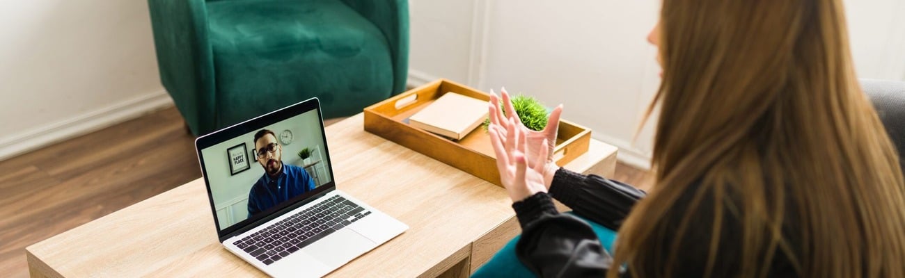 Woman video conferencing with man on laptop.