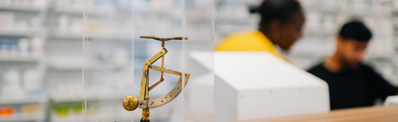 An antique medical instrument in a clear display case