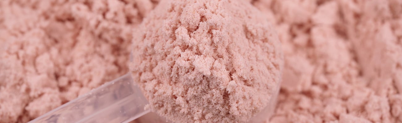 Pile of pink protein powder supplement