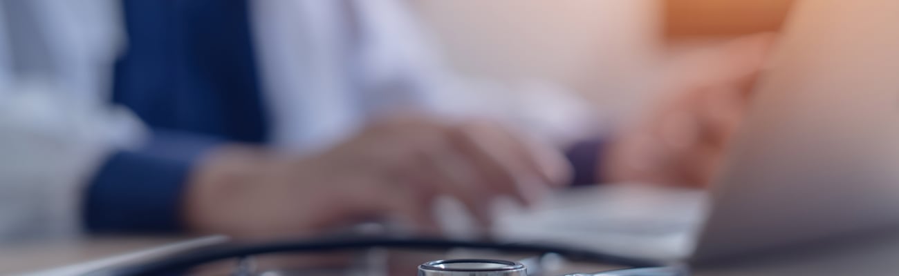 A doctor sits in front of a computer